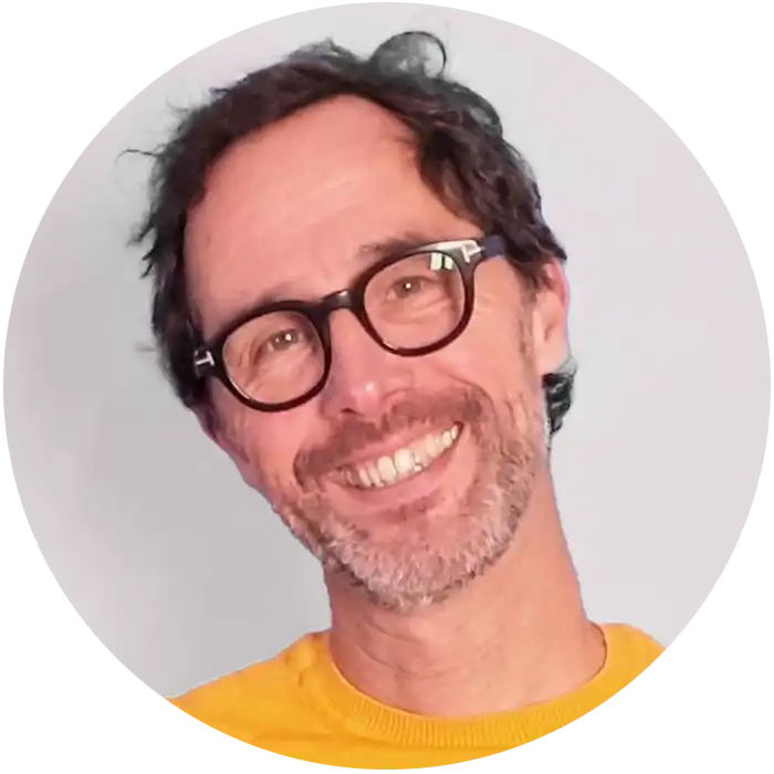 Portrait d'Alex avec un sourire bienveillant et un regard confiant.